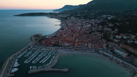 Menton-An-Der-Französischen-Riviera-In-Der-Abenddämmerung,-Zeigt-Die-Küste-Und-Das-Stadtgebiet,-Luftaufnahme