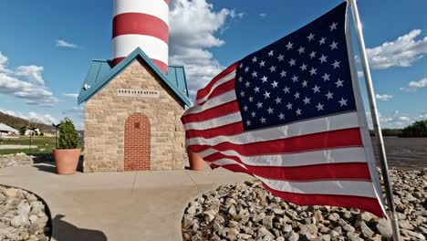 Leuchtturm-Am-Hafen-Von-Grafton-Mit-Amerikanischen-Flaggen,-Die-In-Zeitlupe-Im-Wind-Wehen,-Entlang-Des-Mississippi-River,-Illinois,-USA