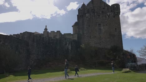 Schwenkaufnahme-Einer-Touristenfamilie,-Die-Eilean-Donan-Castle-Erkundet