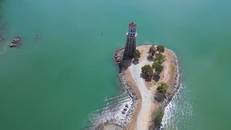 Einsamer-Leuchtturm-Auf-Einer-Landzunge-Mit-Malerischem-Tropischen-Strand