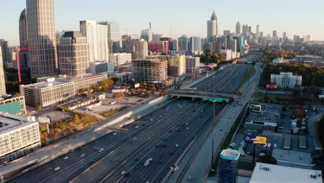 Aerial-of-Midtown-Atlanta-skyscrapers,-Downtown-Atlanta,-Horace-E-Tate-freeway-traffic-in-the-evening,-Georgia,-USA