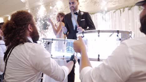 Slow-motion-shot-of-a-bride-and-groom-playing-the-drums-on-the-dancefloor