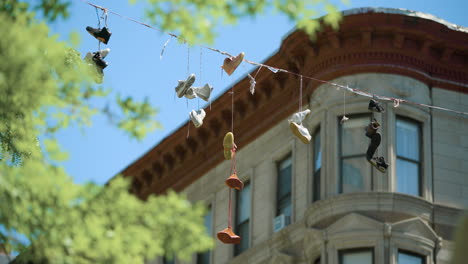 Los-Zapatos-Se-Balancean-Desde-El-Cable-Eléctrico-Visto-A-Través-De-Los-árboles-En-Harlem,-Nueva-York.