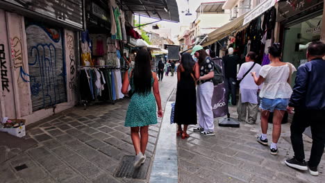 Tourists-walking-in-narrow-streets-of-Monastiraki-Square-passing-street-vendors-selling-clothes