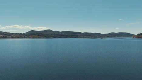 Drone-shot-in-Hawaii,-flying-towards-the-Island,-Sunny-weather,-dreamy-atmosphere,-reflection-on-the-water,-4K-video