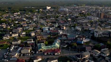 Hermoso-Dron-Inclinado-Sobre-La-Ciudad-De-Kawaguchiko-Y-El-Monte-Fuji-En-La-Distancia