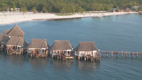 Aerial-view-orbiting-luxurious-thatched-roof-Kae-Funk-chalets-Indian-ocean-beach-resort-in-Zanzibar-Chwaka-bay