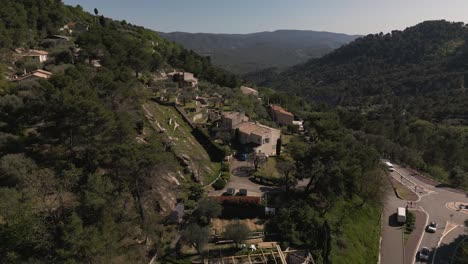 A-serene-house-nestled-in-the-lush-greenery-of-the-french-riviera-countryside,-sunlight-dappling-the-scene,-aerial-view