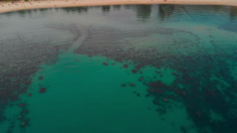 Toma-Aérea-De-Un-Dron-De-Un-Complejo-De-Playa-Tropical-Rodeado-De-Exuberante-Vegetación-Y-Aguas-Cristalinas,-Que-Muestra-Un-Sereno-Paisaje-Costero-En-Tailandia