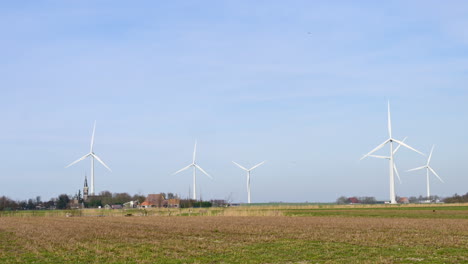 Windturbines-in-an-agricultural-field-around-a-small-village-in-the-Netherlands,-Europe