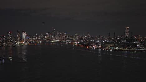 Nyc-Nueva-York-Antena-V177-Drone-Sobrevuelo-Del-Río-Este,-Vistas-Panorámicas-Que-Capturan-El-Paisaje-Urbano-De-Rascacielos-Iluminados-Del-Bajo-Manhattan-Y-Brooklyn-Por-La-Noche---Filmado-Con-Inspire-3-8k---Septiembre-De-2023