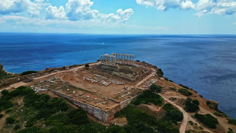 Drone-Shot,-Archaeological-Site-of-Sounion-and-Temple-of-Poseidon-Ruins-on-Hill-Above-Sea,-Greece