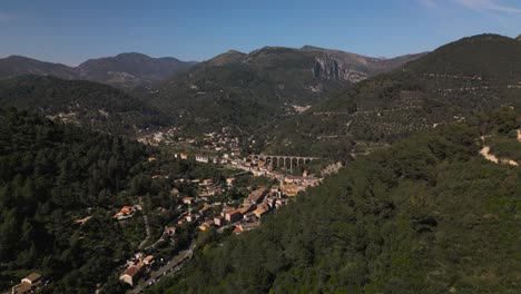 A-quaint-village-nestled-in-the-lush-forests-of-the-french-riviera,-under-clear-skies,-aerial-view