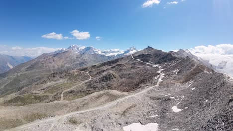 Flight-over-the-Alps-mountains-in-Gornergrat,-Zermatt,-in-Switzerland-with-the-reveal-view-of-a-beautiful-glacier