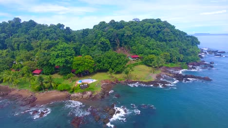 Deslizándose-A-Lo-Largo-De-Una-Exuberante-Costa-Verde-Cubierta-De-Palmeras-Y-Pequeñas-Villas-En-Una-Isla-De-Costa-Rica