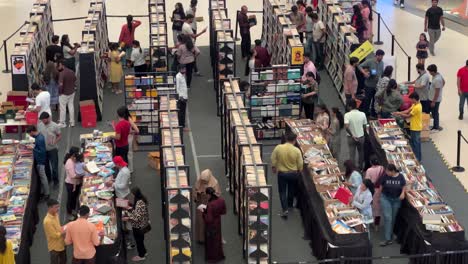 De-Cerca-Se-Ve-Gente-Comprando-Libros-Y-Mucha-Gente-Mirando