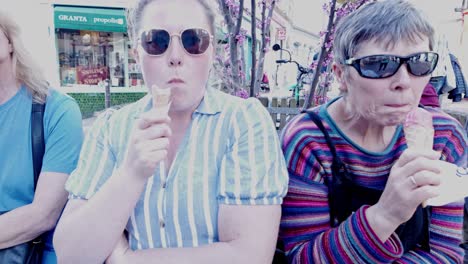 Mother-and-daughter-sitting-enjoying-tasty-ice-cream-cones-sunny-city-day-Close-up