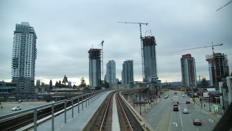 POV-Vom-Skytrain-Bei-Ankunft-An-Der-Station-Burquitlam-Mit-Im-Bau-Befindlicher-Wohnanlage-In-Coquitlam,-Vancouver,-BC,-Kanada