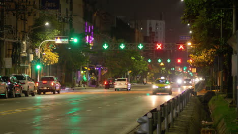 Evening-road-shot-of-cars-traveling-at-night,-showing-green-arrows-and-red-x-lights