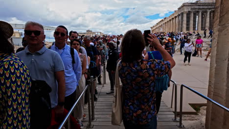 Line-of-tourists-walking-towards-Parthenon-temple-in-Athens-acropolis