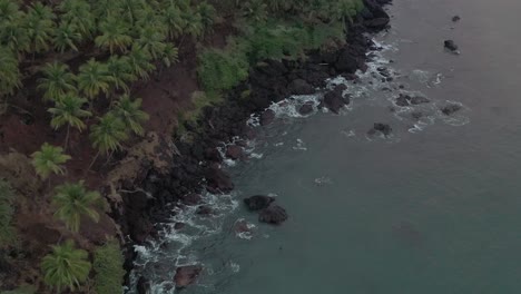 Aerial-top-view-on-tropical-beach-with-green-waves-reaching-the-water-shore