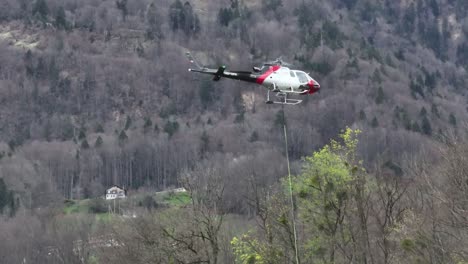 The-Swiss-Airbus-H125,-a-nimble-single-engine-utility-helicopter,-expertly-performs-precise-rope-handling-maneuvers