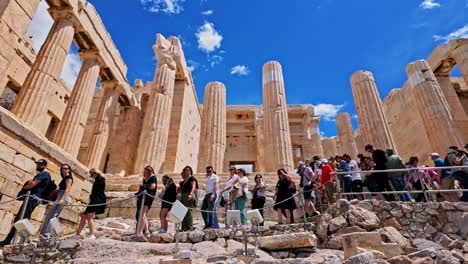 Turistas-En-Línea-Visitando-El-Monumento-Del-Pedestal-De-Agripa-En-Atenas,-Grecia