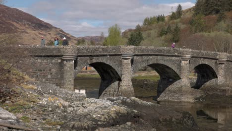 Handaufnahme-Von-Touristen,-Die-über-Die-Brücke-In-Richtung-Eilean-Donan-Castle-Gehen