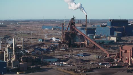 Ausgedehnter-Industriekomplex-Mit-Schornsteinen-Und-Stahlkonstruktionen,-Klarer-Blauer-Himmel