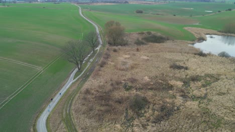 Luftaufnahme-über-Der-Landstraße-Zwischen-Landwirtschaftlichen-Feldern---Drohnenaufnahme