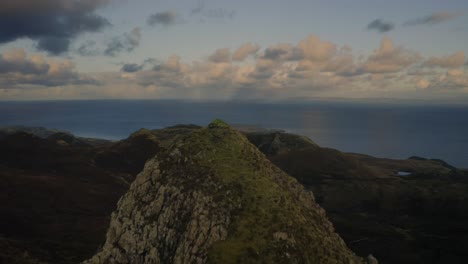 La-Antena-Sobre-Un-Pico-Rocoso-En-Las-Tierras-Altas-De-Escocia-Revela-El-Océano-Y-El-Cielo-Nublado-En-El-Horizonte,-Isla-De-Skye,-Escocia