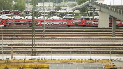 Multiple-railway-tracks-at-a-station-with-an-automobile-transport-train-loaded-with-cars