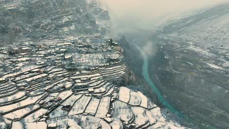 Vista-Aérea-De-La-Zona-Cubierta-De-Nieve-De-Karimabad-En-Hunza,-Pakistán