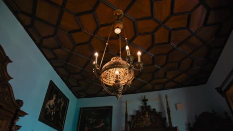 Richly-decorated-chandelier-hangs-from-an-ornate-wooden-ceiling-in-Trakošćan-Castle's-dining-room,-Croatia