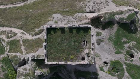 Flug-Mit-Einer-Drohne-Mit-Blick-Von-Oben-Auf-Den-Bergfried-Der-Burg-Von-Oreja-Aus-Dem-9.-Jahrhundert.-Wir-Sehen-Den-Schatten-Der-Zinnen,-Das-Erddach-Auf-Dem-Boden,-Reste-Der-Mauer,-Ontigola,-Toledo