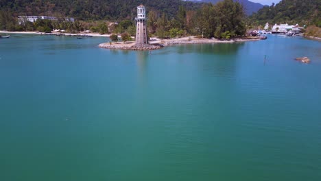 Solitary-lighthouse-on-headland-with-scenic-tropical-beach