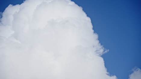 Fluffy-white-clouds-move-swiftly-across-a-bright-blue-sky-in-a-dynamic-timelapse