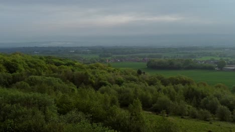 Vista-Panorámica-Aérea-Del-Dosel-De-Las-Copas-De-Los-árboles-Del-Bosque-Que-Establece-La-Campiña-De-Lancashire-Y-La-Cordillera-De-Winter-Hill