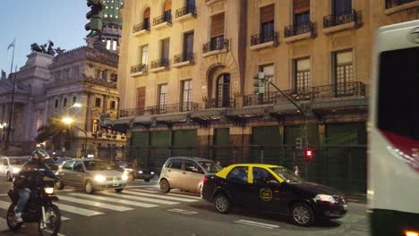 Traffic-at-buenos-aires-city-night,-argentina-congressional-building-background