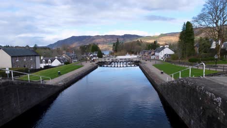 View-of-Caledonian-Canal,-locks-and-swing-bridge-overlooking-Loch-Ness-in-popular-tourism-destination-of-Fort-Augustus-in-the-highlands-of-Scotland-UK