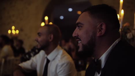 slow-motion-shot-of-male-guests-smiling-and-enjoying-the-wedding-reception