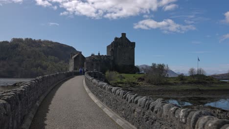 POV-shot-following-a-family-heading-to-explore-the-famous-Eilean-Donan-Castle