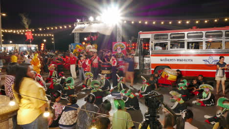 Toma-De-Tiempo-De-Artistas-De-Danza-Del-León-En-La-Celebración-Del-Festival-Del-Año-Nuevo-Chino-En-El-Suelo-Junto-A-Su-Transporte-De-Autobús-Rojo-Mientras-Esperan-Su-Turno-Para-Actuar