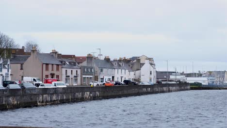 Vista-De-La-Ciudad-De-Stornoway-Con-Casas-Frente-Al-Puerto-Y-Al-Río-Y-Autos-Estacionados-En-Las-Hébridas-Exteriores-De-Escocia,-Reino-Unido