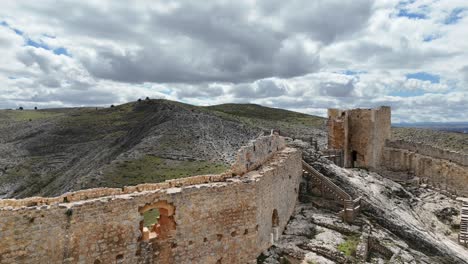Aerial-spinning-drone-flight-around-a-medieval-Castle-in-Burgo-de-Osma-medieval-city-in-Soria,-Spain