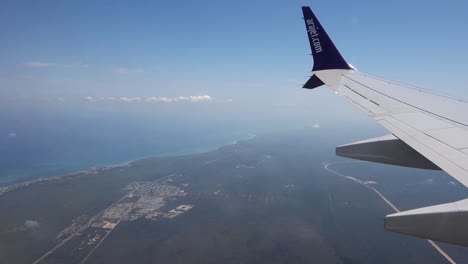 view-of-the-wing-of-the-low-cost-company-Arajet-plane,-from-Dominican-Republic,-flying-over-Caribbean-coast