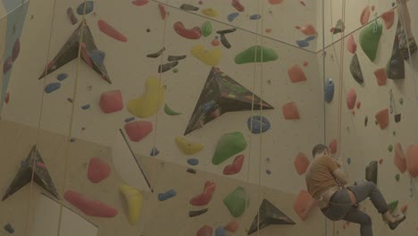 Person,-Die-Sich-Von-Einer-Farbenfrohen-Indoor-Kletterwand-Abseilt