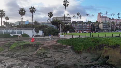 La-Jolla-Cove-Drone-Horizontal-Fly-Backwards-Away-From-Park-and-Coast-out-over-the-ocean