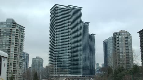 Tall-Buildings-Seen-From-A-Traveling-Train-In-Vancouver,-British-Columbia,-Canada