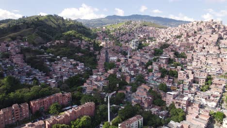 Densely-populated-homes-of-Communa-13-and-Metrocable-in-Medellin-Colombia,-aerial